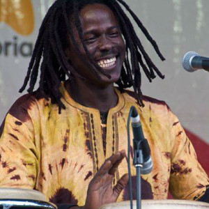 African drummer smiling, playing djembe