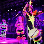 dancers posing for photo with bright fluro costumes